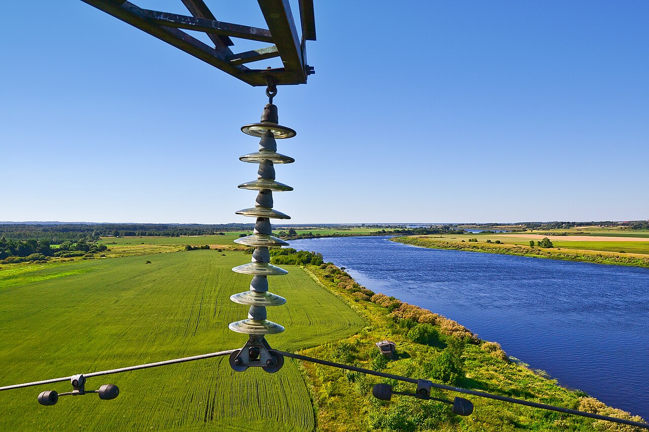 Stockbridge vibration dampers with paired dogbone end masses clamped to overhead transmission-line conductors below a glass insulator string